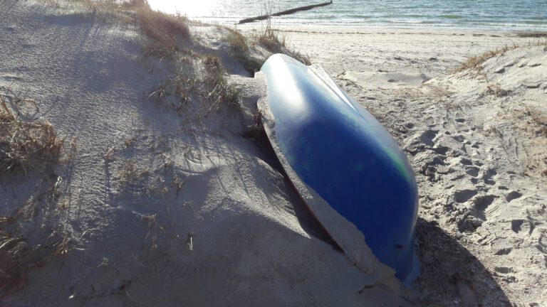 Ein blaues Ruderboot liegt am Strand